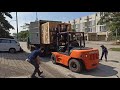 Unloading machine from shipping container with forklift