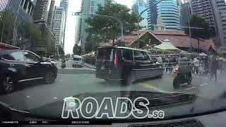 Motorcylist going straight on a turn right lane, almost colliding with a car outside Lau Pa Sat