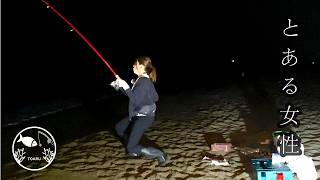 Woman gets very excited after catching a horse mackerel from the surf