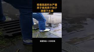 眼看路面积水严重        男子竟用两个钩子清理下水道