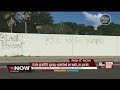 Hate graffiti spray-painted on wall and in yards