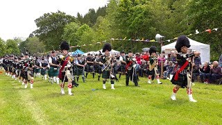 Massed pipe bands parade before Chieftain at opening of 2019 Drumtochty Highland Games in Scotland