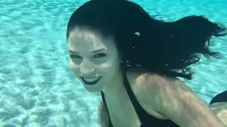 @trinamason underwater at the pool with dyed black hair and black lipstick