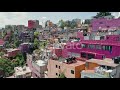 drone is flying along colorful slum suburban district in mexico city