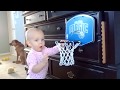 Cute baby slam dunks basketball in hoop