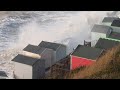 extraordinary moment huge waves wash beach huts into the sea