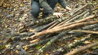 Building complete and warm survival shelter Bushcraft earth hut, grass roof fireplace with clay
