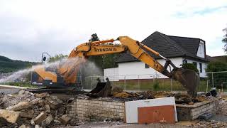 Hyundai 235 LCR-9A short tail swing excavator clearing up debris after a demolition.