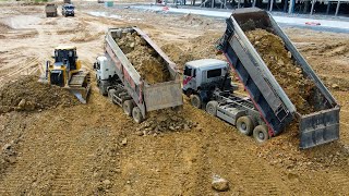 Excellent Bulldozer Filling Land spreading dirt and soil using a truck in order to get to the water