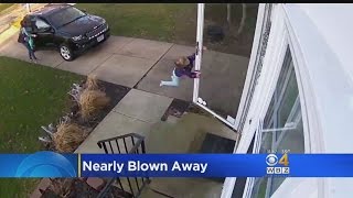 Girl Hangs On To Door As Wind Nearly Blows Her Away