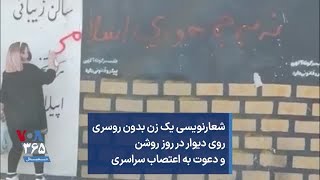 شعارنویسی یک زن بدون روسری روی دیوار در روز روشن و دعوت به اعتصاب سراسری