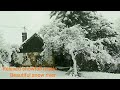 Relaxing snow falling and wind blowing sounds in a winter landscape with an old cozy cabin