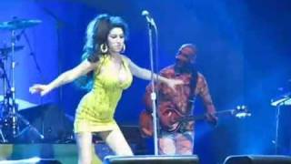 Amy Winehouse faz pirueta e cai no palco durante show