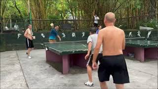 快乐乒乓，公园里挑战手机打球，happy table tennis game, using cell phone instead of paddle to play table tennis.