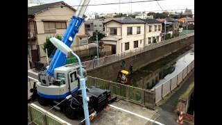 引き上げ（川底掃除の小型パワーショベルをクレーンで橋の上に）