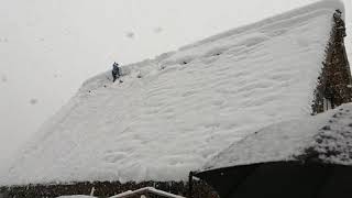 雪乡，游客非常高兴的欣赏雪景，为防止把房子压塌除雪也很辛苦呀