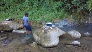 Callaloo salt fish fritters - cooking on big stone in the river