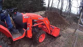 kubota B2650 moving farm waste and piling it higher