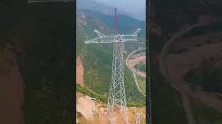 skilled workers installing high voltage electric tower at high mountain