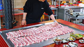 Pork belly grilled on an extra large iron plate with a smoky flavor - Korean street food