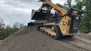 Cat 259D skid steer pushing gravel