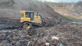 Pushing a sludge pond over a big edge... FILTHY!  Caterpillar D6 Bulldozer