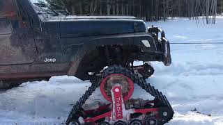 Jeep with tracks, pulling out a suburban