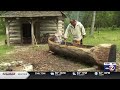 Oneida Tribe member building a burned-out canoe at Heritage Hill