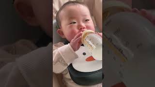 両手で哺乳瓶を持ってミルクを飲む赤ちゃんbaby has Calma Breastmilk Bottle Teat for Encouraging Breastfeeding - Medela