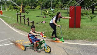 CRIANÇA BRINCANDO NO PARQUE COM PATINETE E TRICICLO