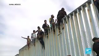 Migrantes escalan el muro fronterizo entre México y Estados Unidos