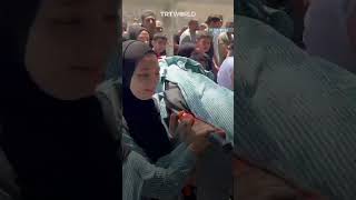 Palestinian schoolgirls carry body of their friend killed by Israeli raid