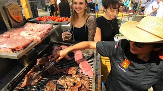 Street Food in Barcelona, Spain. Grilling Hanging Tenderloin Steaks. 'Meat\u0026Fire' Grill Fest