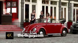 4K UHD - People walk around old vintage red car parked in old city street