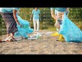 low shot of youth volunteers gathering trash on the lake shore picking up garbage