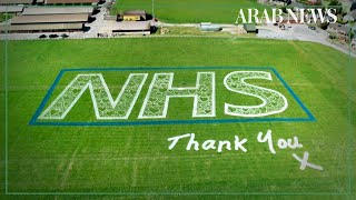 UK artist makes giant NHS logo field art in support of health workers