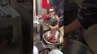 The woman uses a sausage stuffer to make sausages.