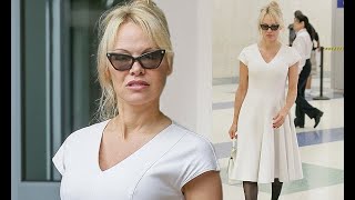 Pamela Anderson displays her eye-popping assets in vintage white dress