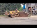 bulldozer pushing the soil into pit on small road complete mitsubishi bd2g dumptruck working