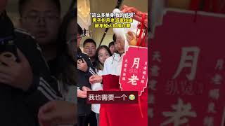 12月15日，陜西西安。一男子裝扮成月老為市民派發紅繩，吸引大量年輕人圍觀，爭相排隊等著發紅繩。（后浪視頻）