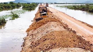 Nice Komatsu Bulldozer Pushing Soil Dumping By Dump Trucks Coverage An Old Road Across Water