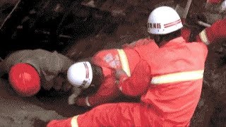 Firefighters use their bare hands to rescue buried workers