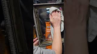 Jen uses wood ash to clean the glass on the stove