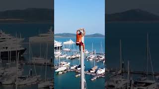 Man at the top of the mast fixing the top light, drone view