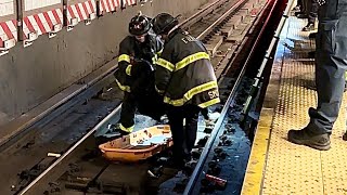 {READ DESCRIPTION}~{FDNY BOX 7394}~{FDNY REMOVING PERSON FROM TRAIN TRACKS AT 125TH STREET, HARLEM}.