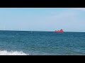 A gigantic ship of Great Yarmouth coast sails through wind farm Norfolk UK