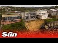 Houses left teetering on cliff edge after huge swells batter Australian coast