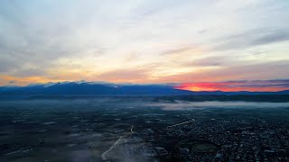 富良野風景・曇天の十勝岳連峰からの朝焼けと日の出、富良野市街地と富良野盆地を一望する「ふらのワインハウス」上空から360度の絶景眺望