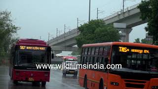 Dhaula Kuan flyover and roundabout in heavy rain, with traffic speeding past