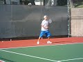 brian battistone hitting 2 forehands with the two handled tennis racket